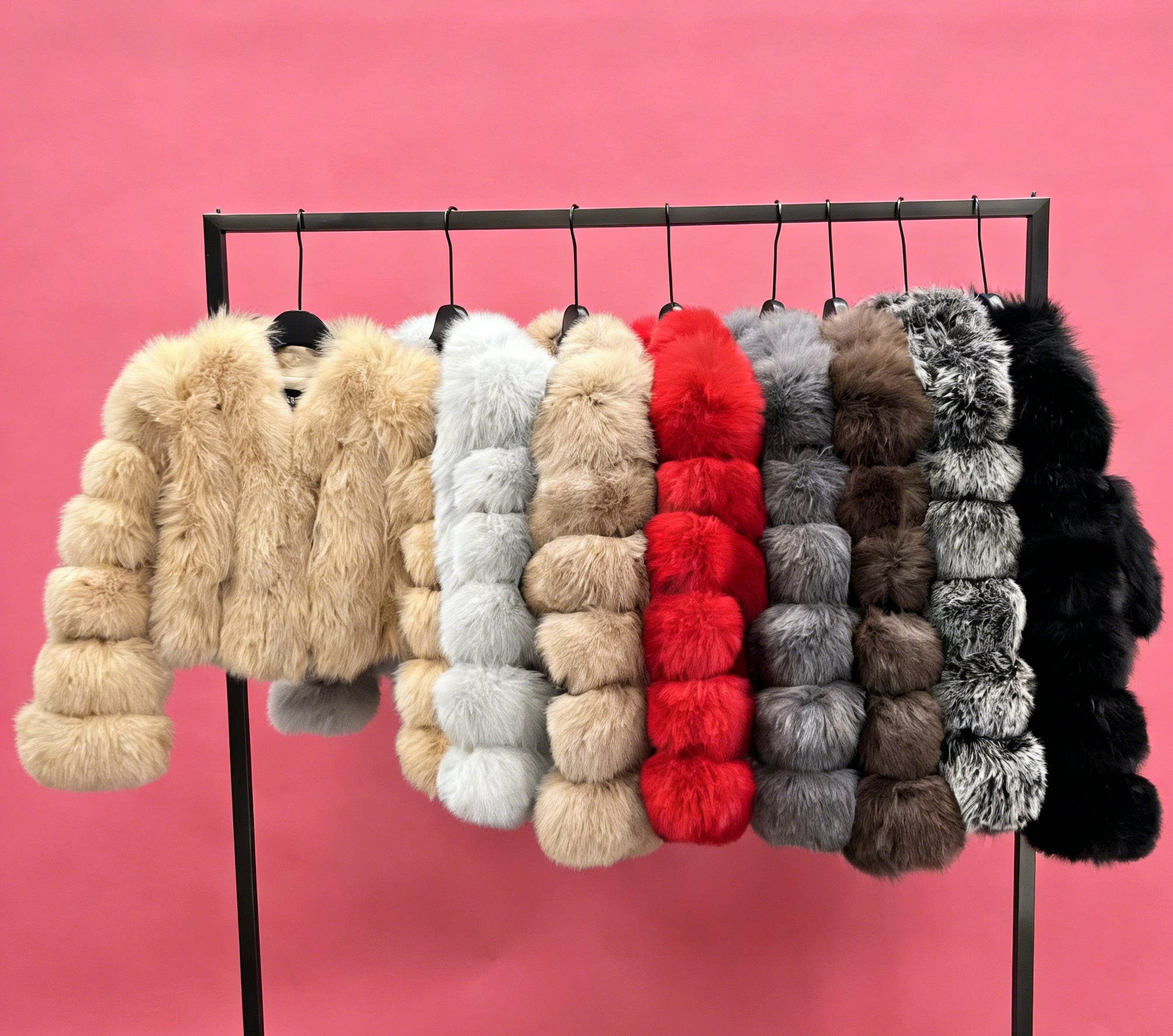 Collection of premium fox fur jackets in various colors including beige, white, red, grey, and black displayed on hangers against pink background
